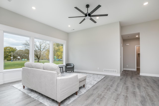 living room featuring light hardwood / wood-style floors and ceiling fan