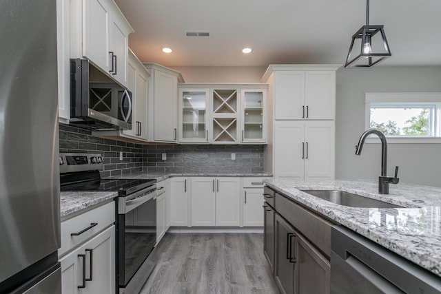 108 Lisa Ct, Hallsville, MO 65255 - kitchen with appliances with stainless steel finishes, a sink, glass insert cabinets, tasteful backsplash, and recessed lighting