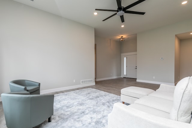 living room with wood-type flooring and ceiling fan