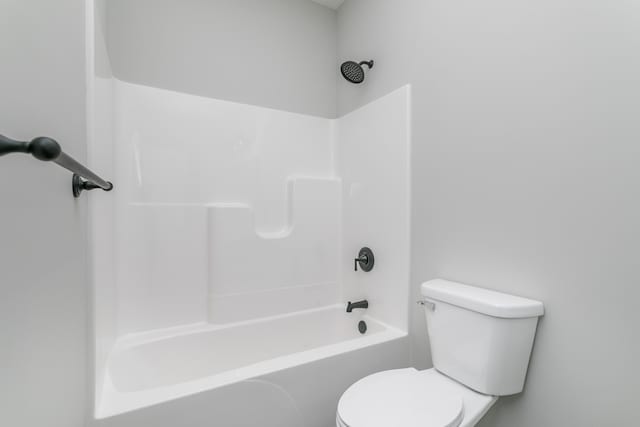 bathroom featuring tub / shower combination and toilet