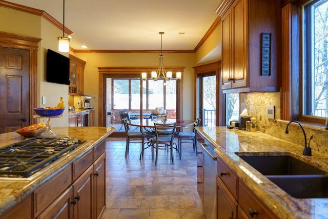 kitchen with plenty of natural light, stainless steel appliances, sink, and decorative light fixtures