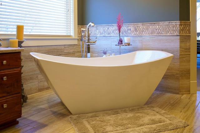 bathroom featuring plenty of natural light, tile walls, and a bathtub