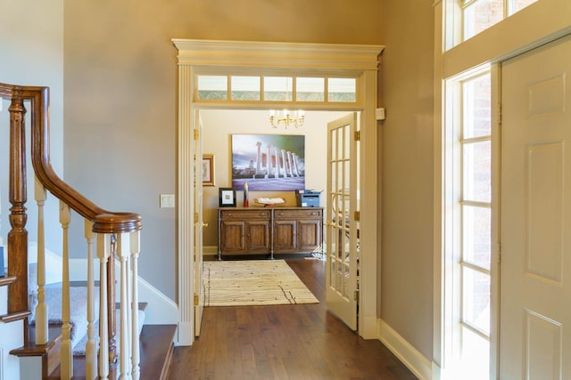 foyer with dark wood-type flooring and a notable chandelier