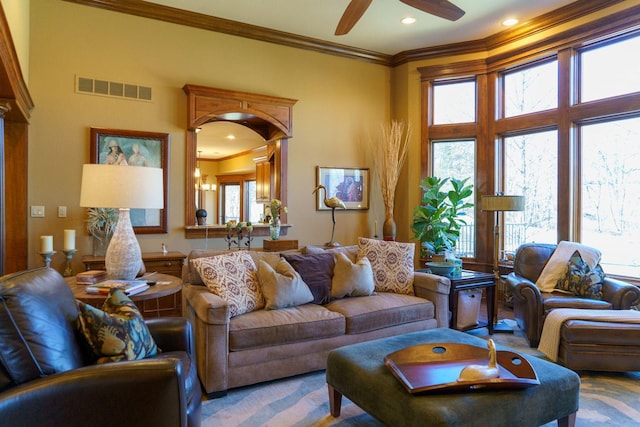 living room with ornamental molding, plenty of natural light, ceiling fan, and carpet floors