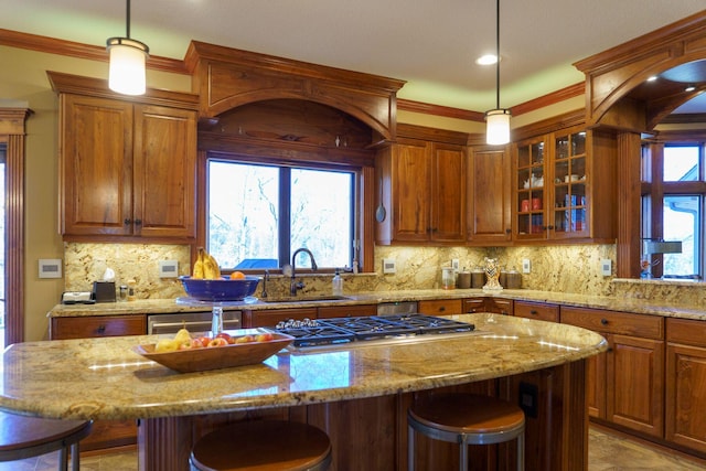 kitchen with backsplash, a breakfast bar area, sink, and hanging light fixtures