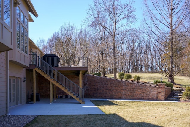 view of yard with a deck, central air condition unit, and a patio area