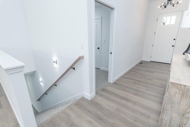 foyer entrance with a chandelier and light hardwood / wood-style floors