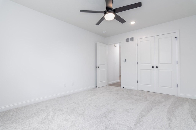 unfurnished bedroom featuring ceiling fan, a closet, and light colored carpet