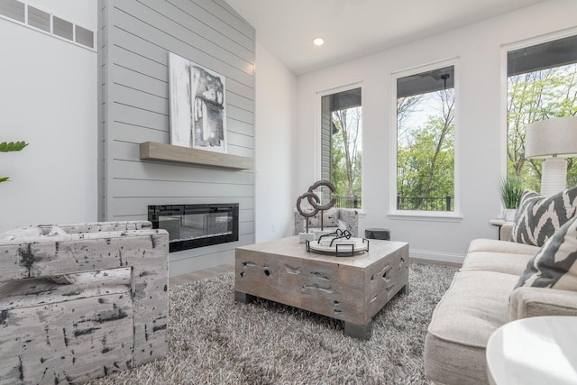 living room featuring a large fireplace and dark wood-type flooring