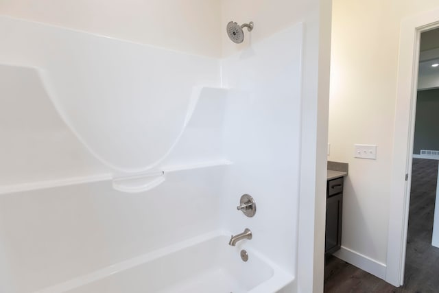 bathroom featuring hardwood / wood-style floors, shower / bathtub combination, and vanity