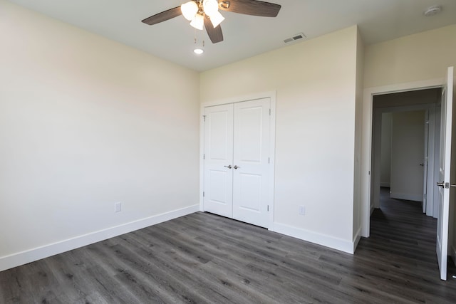 unfurnished bedroom featuring a closet, ceiling fan, and dark wood-type flooring