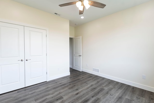 unfurnished bedroom with dark wood-type flooring, a closet, and ceiling fan