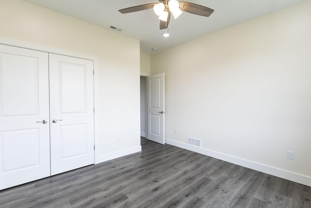 unfurnished bedroom featuring a closet, visible vents, baseboards, and wood finished floors