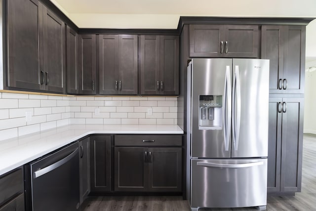 kitchen with dark brown cabinets, stainless steel fridge, dishwasher, and dark wood finished floors