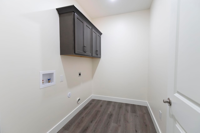 clothes washing area featuring dark wood-type flooring, hookup for a washing machine, cabinets, electric dryer hookup, and hookup for a gas dryer