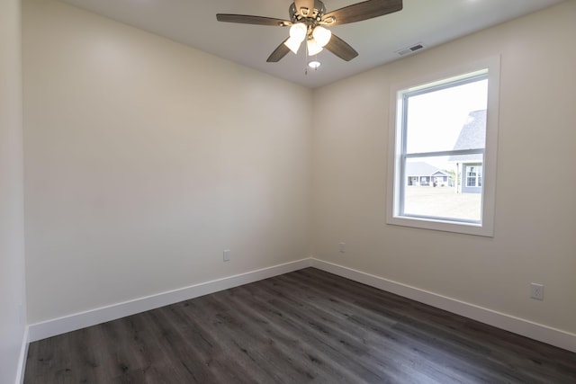unfurnished room with visible vents, a ceiling fan, dark wood-type flooring, and baseboards