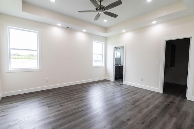unfurnished bedroom with recessed lighting, multiple windows, and a raised ceiling