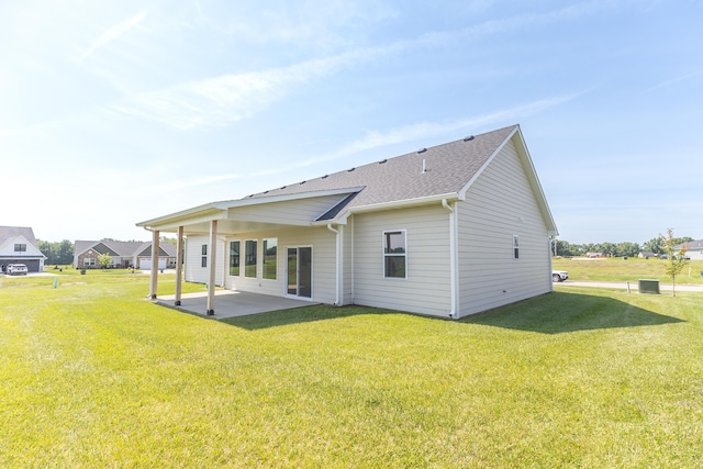 911 Destinee Dr, Moberly, MO 65270 - back of property featuring a patio area, a lawn, and a shingled roof