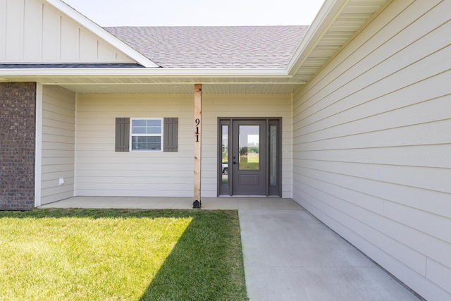 911 Destinee Dr, Moberly, MO 65270 - entrance to property featuring board and batten siding, a shingled roof, and a lawn
