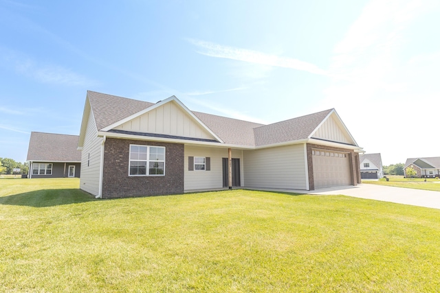 911 Destinee Dr, Moberly, MO 65270 - view of front of home featuring board and batten siding, brick siding, concrete driveway, an attached garage, and a front lawn