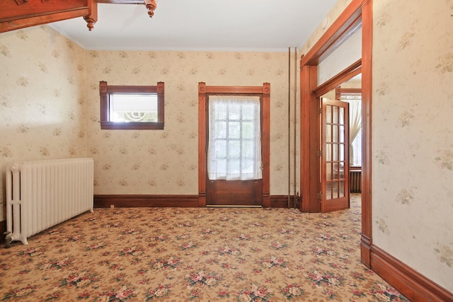 carpeted spare room featuring radiator