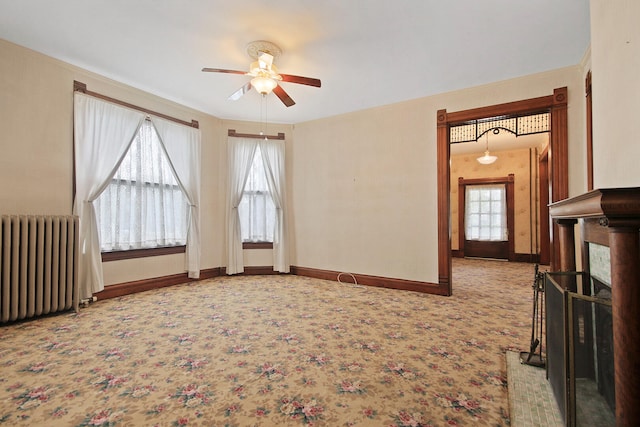 spare room with radiator, ceiling fan, and carpet floors