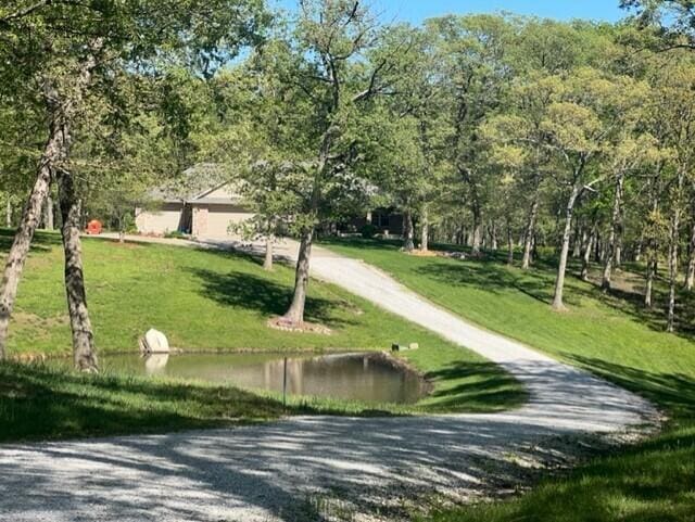 view of home's community featuring a water view and a lawn