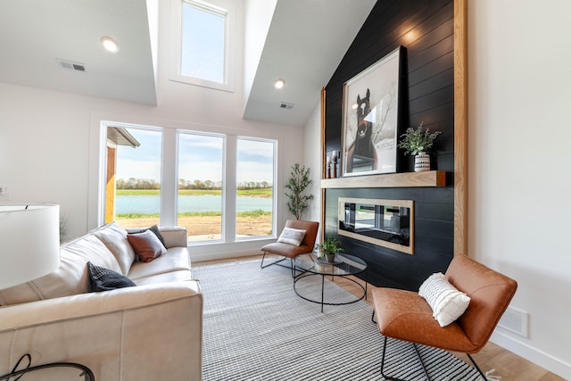 living room featuring vaulted ceiling, a water view, and hardwood / wood-style floors