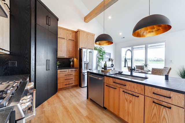 kitchen with light wood-type flooring, pendant lighting, lofted ceiling with beams, premium appliances, and sink