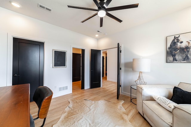 living room featuring ceiling fan and light hardwood / wood-style floors