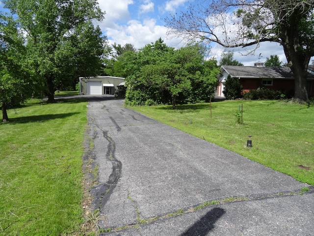 view of front of home with a front yard, an outdoor structure, and a garage