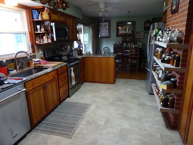 kitchen featuring ceiling fan, kitchen peninsula, backsplash, sink, and appliances with stainless steel finishes