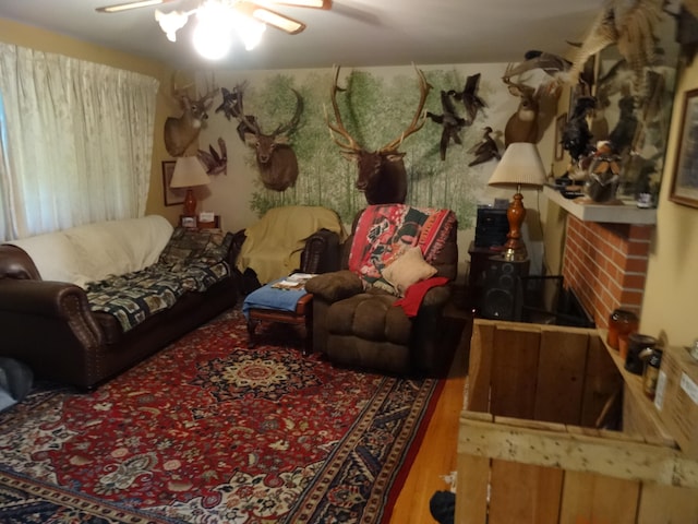 living room featuring a brick fireplace, ceiling fan, and hardwood / wood-style floors