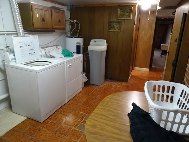 clothes washing area featuring separate washer and dryer, wood walls, electric water heater, and light tile floors