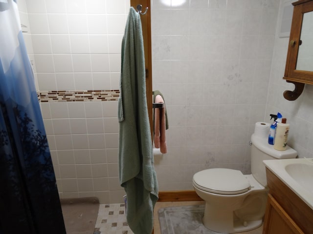 bathroom featuring tile walls, toilet, a shower with shower curtain, tile flooring, and vanity