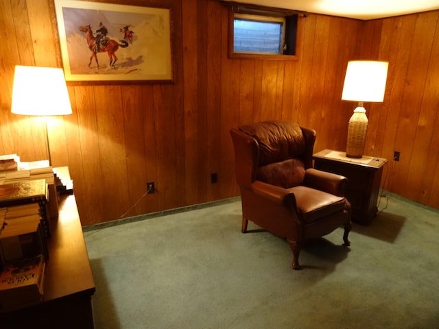 sitting room featuring carpet flooring and wood walls