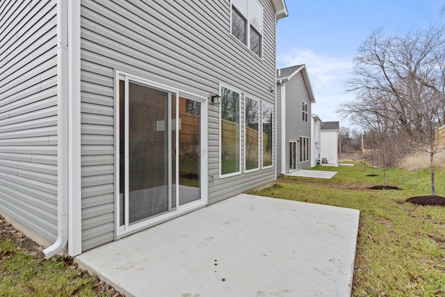 view of side of property featuring a lawn and a patio