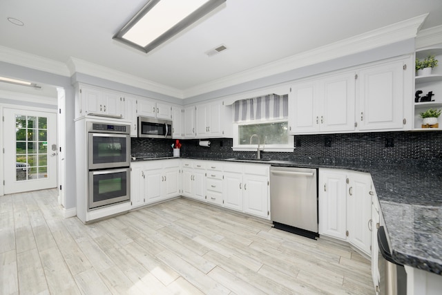 kitchen featuring white cabinets, appliances with stainless steel finishes, sink, and backsplash