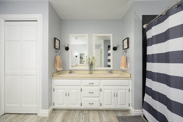 bathroom with dual sinks, hardwood / wood-style floors, and large vanity