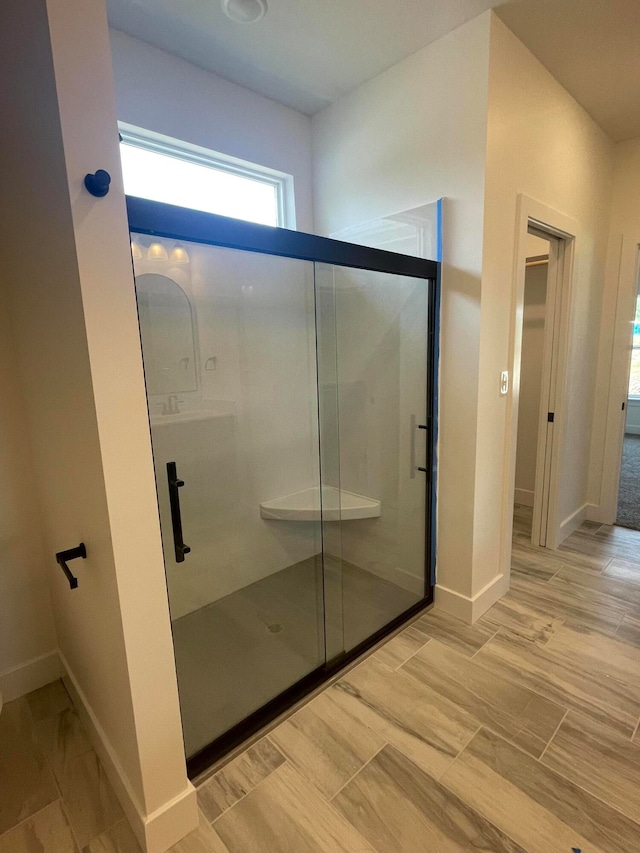 bathroom with hardwood / wood-style floors and an enclosed shower