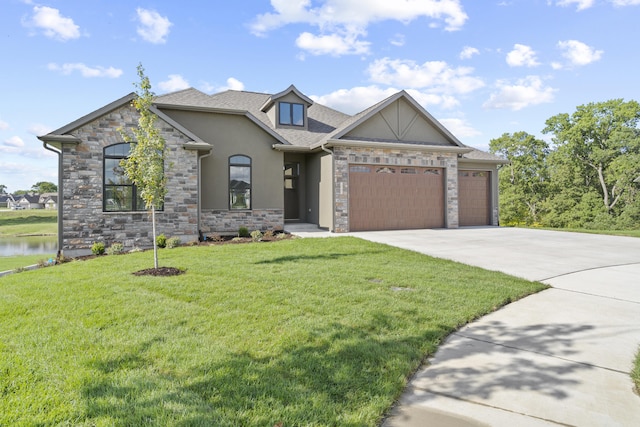 view of front of house featuring a front yard, a water view, and a garage