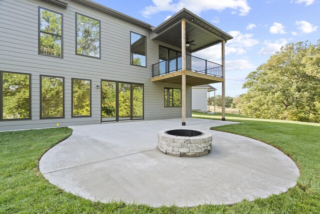 1704 Stillpoint Ct, Columbia, MO 65203 - back of house featuring a balcony, an outdoor fire pit, a ceiling fan, a yard, and a patio area