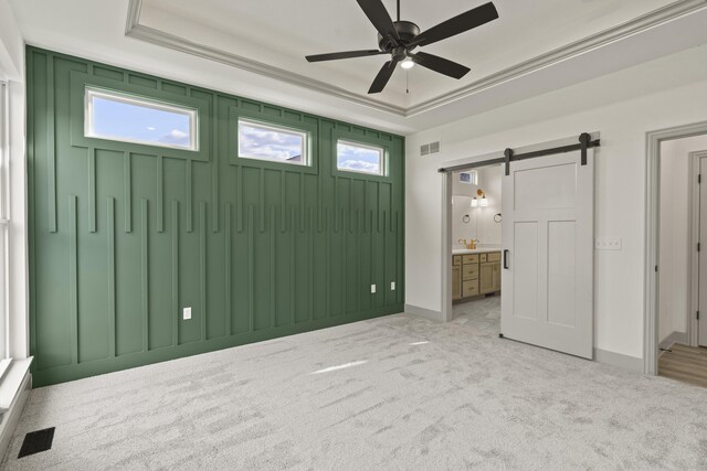 1704 Stillpoint Ct, Columbia, MO 65203 - unfurnished bedroom featuring a barn door, a tray ceiling, and multiple windows