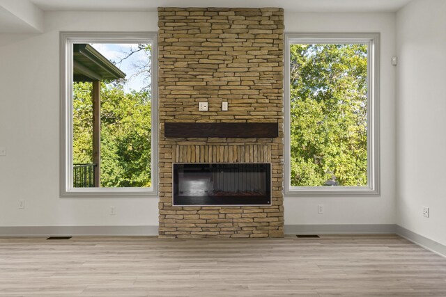 1704 Stillpoint Ct, Columbia, MO 65203 - unfurnished living room with visible vents, a fireplace, wood finished floors, and plenty of natural light
