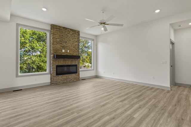 1704 Stillpoint Ct, Columbia, MO 65203 - unfurnished living room featuring baseboards, light wood-style flooring, a ceiling fan, and a stone fireplace