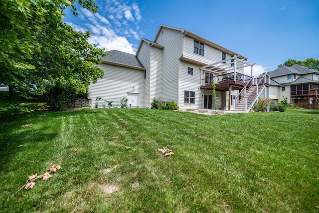 rear view of property featuring a pergola, a wooden deck, and a lawn