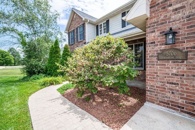 entrance to property with a lawn