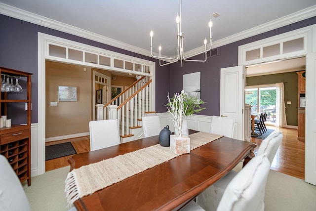 dining area featuring light hardwood / wood-style floors, crown molding, and a chandelier