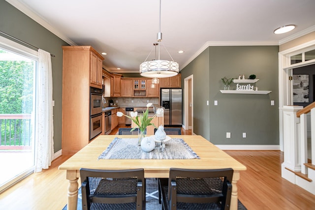 dining room with crown molding and light hardwood / wood-style floors