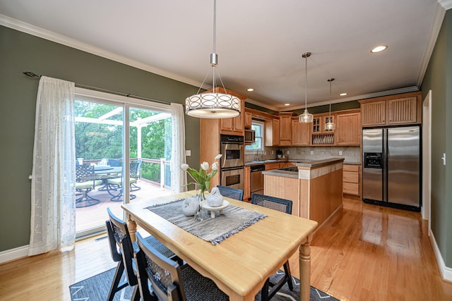 dining room featuring ornamental molding, light hardwood / wood-style floors, and sink